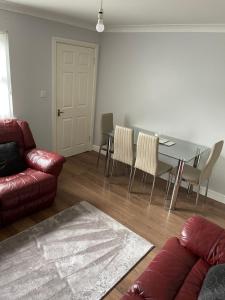 sala de estar con mesa, sillas y sofá en Fife Apartments, en Dunfermline