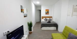 a room with a bed and a tv and a couch at Apartamento interior en el absoluto centro BA in Algeciras
