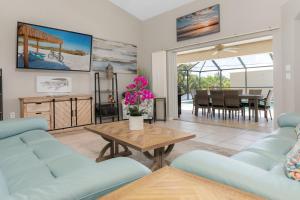 una sala de estar con sofás azules y una mesa. en Punta Paradise- Enjoy a 4 bedroom pool home, en Punta Gorda