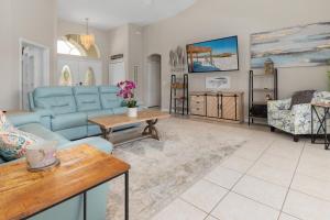 a living room with a blue couch and a table at Punta Paradise- Enjoy a 4 bedroom pool home in Punta Gorda