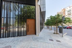 a building with a wooden door on a city street at Travel Habitat Alameda Suites. in Valencia