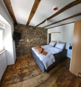 1 dormitorio con cama y pared de piedra en Haus zur Heugabel, en Kesten