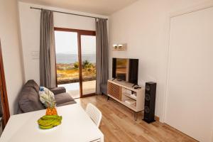 uma sala de estar com uma mesa e uma televisão em Casa Tabaiba Dulce em Jerez de la Frontera