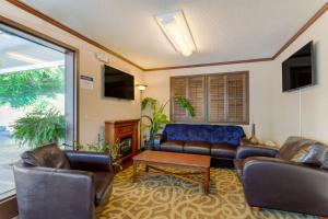 sala de estar con muebles de cuero y ventana grande en Best Western Smoky Mountain Inn, en Waynesville