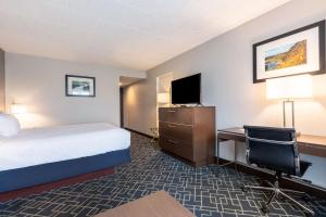 a hotel room with a bed and a desk and a tv at Best Western Hunt's Landing Hotel Matamoras Milford in Matamoras