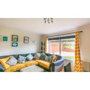 a living room with a couch and a window at Home to Home Stay Apartment in Hogganfield