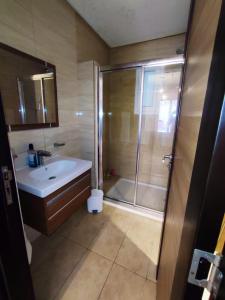 ein Bad mit einer Dusche und einem Waschbecken in der Unterkunft Résidence Amwej Sousse les pieds dans l'eau in Sousse