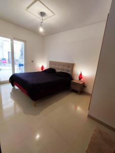 ein Schlafzimmer mit einem schwarzen Bett und einem Fenster in der Unterkunft Résidence Amwej Sousse les pieds dans l'eau in Sousse
