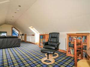 a living room with a black chair and book shelves at St Kilda in Balranald