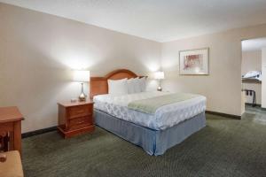 a hotel room with a bed and a table and lamps at SureStay Plus Hotel by Best Western Reno Airport in Reno