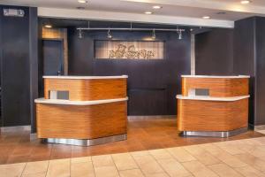 a lobby with two wooden counters in a room at Sonesta Select Allentown Bethlehem Airport in Allentown