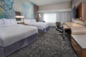 a hotel room with two beds and a desk at Sonesta Select Allentown Bethlehem Airport in Allentown