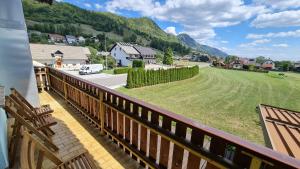 a balcony with a view of a field and mountains at Pension Knafel in Žirovnica