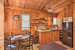 a kitchen with wooden walls and a table with chairs at Rustic Suttons Bay Cottage Shared Dock and Fire Pit in Suttons Bay