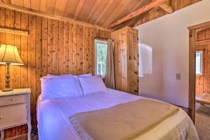 a bedroom with a bed in a room with wooden walls at Cozy Suttons Bay Cottage with Shared Dock and Fire Pit in Suttons Bay