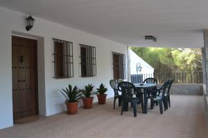 une terrasse avec une table, des chaises et des plantes dans l'établissement Alojamiento Rural Dehesa La Estancia, à Andújar