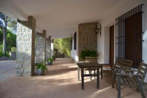 un patio con mesa y sillas en un edificio en Alojamiento Rural Dehesa La Estancia en Andújar