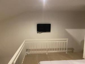 a flat screen tv on a wall in a bedroom at Odadi Guesthouse in Dalung