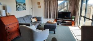 Una sala de estar con un sofá y un televisor. en Ohope Lifestyles, en Ohope Beach