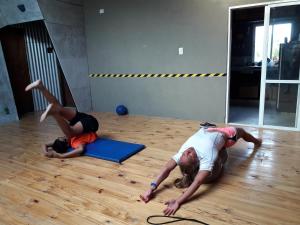 tres personas tiradas en el suelo en un gimnasio en Puro Deporte entrenamiento y hospedaje en Necochea