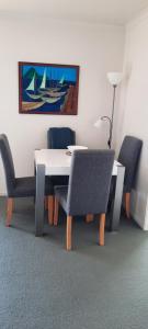 mesa de comedor y sillas con una pintura en la pared en Ohope Lifestyles, en Ohope Beach