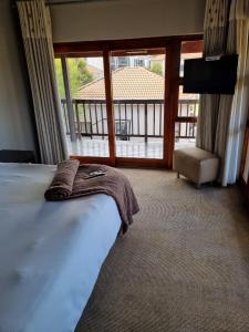 1 dormitorio con cama y vistas a un balcón en Emufuleni river logde en Vanderbijlpark