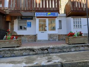 a building with a door and flowers in front of it at BUENAVISTA DELUXE in Sierra Nevada