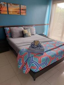 Cama en habitación con pared azul en Playa Tamarindo, CasaMar de Tamarindo, en Tamarindo