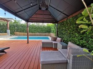 a wooden deck with chairs and a swimming pool at Playa Tamarindo, CasaMar de Tamarindo in Tamarindo