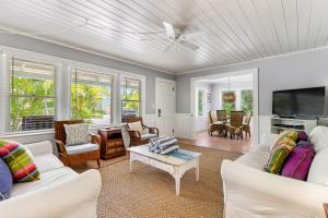 un soggiorno con mobili bianchi e TV a schermo piatto di Sea Palm Cottage a Ilexhurst