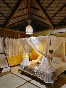 um quarto com uma cama com redes mosquiteiras em Casa das Rendas em Praia de Moitas