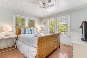 una camera con letto, ventilatore a soffitto e finestre di Sea Palm Cottage a Ilexhurst Altre 25 foto