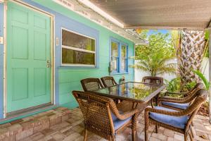 patio con tavolo, sedie e porta di Sea Palm Cottage a Ilexhurst