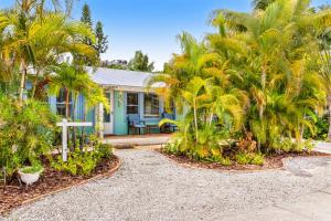 una casa con delle palme davanti di Sea Palm Cottage a Ilexhurst