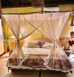 a bedroom with a bed with mosquito netting at Casa das Rendas in Praia de Moitas