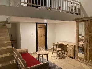 a living room with a staircase and a couch and a table at Odadi Guesthouse in Dalung