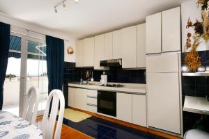 a kitchen with white cabinets and a stove top oven at Apartments with parking space Selce, Crikvenica - 5366 in Selce
