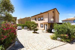 a courtyard with cars parked in front of a building at Apartments with a swimming pool Punat, Krk - 5378 in Punat