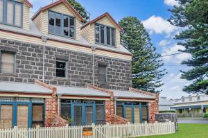 a house with a white fence in front of it at Docks At The Mill in Port Fairy