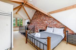 a bedroom with a brick wall at Docks At The Mill in Port Fairy