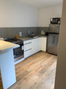 a kitchen with white cabinets and stainless steel appliances at 11 de abril. Loft in Bahía Blanca