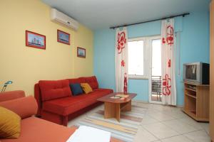 a living room with a red couch and a tv at Apartments and rooms with parking space Makarska - 6834 in Makarska