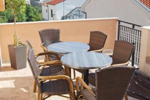 a group of tables and chairs on a balcony at Apartments and rooms with parking space Makarska - 6834 in Makarska