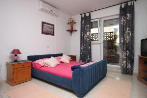 a bedroom with a blue bed with pink sheets at Apartments and rooms with parking space Makarska - 6834 in Makarska