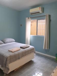 um quarto azul com uma cama e uma janela em Casa 170 em Belém