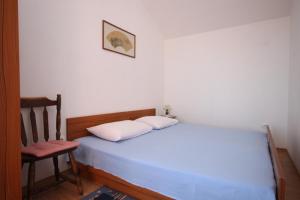 a small bedroom with a bed and a chair at Apartments with a parking space Gradac, Makarska - 6757 in Gradac