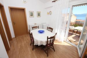 a dining room with a table and chairs and a balcony at Apartments with a parking space Gradac, Makarska - 6757 in Gradac
