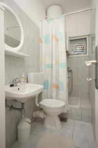 a bathroom with a toilet and a sink and a shower curtain at Apartments with a parking space Gradac, Makarska - 6757 in Gradac