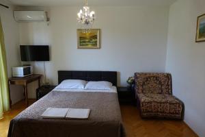 een slaapkamer met een bed en een stoel bij Apartments by the sea Podaca, Makarska - 6821 in Podaca