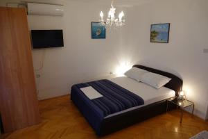 een slaapkamer met een bed en een kroonluchter bij Apartments by the sea Podaca, Makarska - 6821 in Podaca